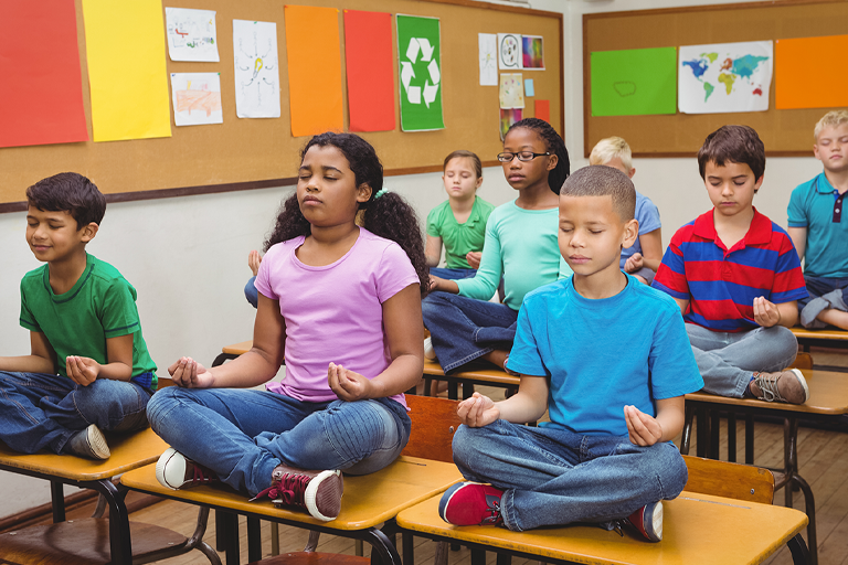 students in classroom doing yoga